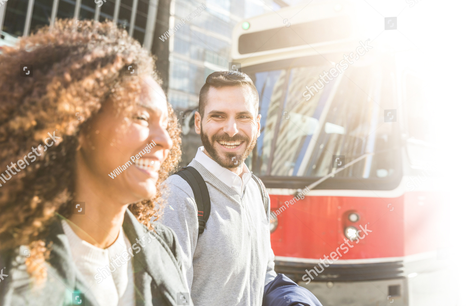 stock-photo-commuters-in-the-city-walking-and-smiling-with-a-tram-on-background-modern-business-man-and-woman-645602095
